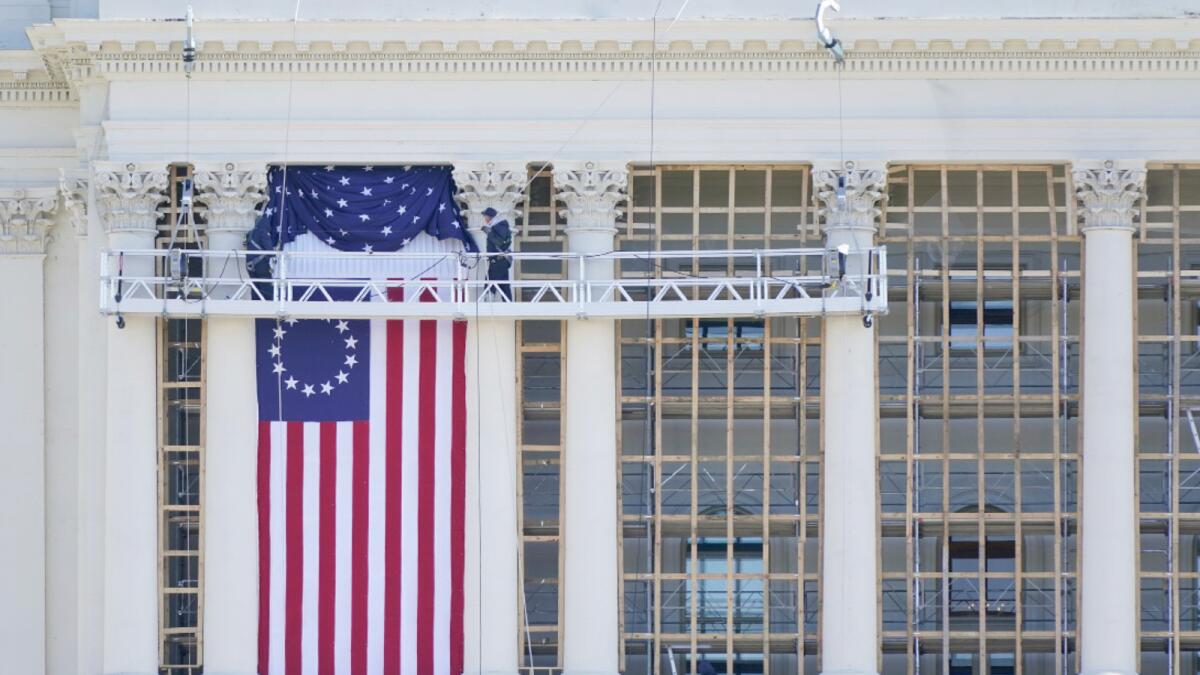 Workers instal a flag on the West Front of the US Capitol as preparations take place for President-elect Joe Biden's inauguration in Washington. Photo: AP
