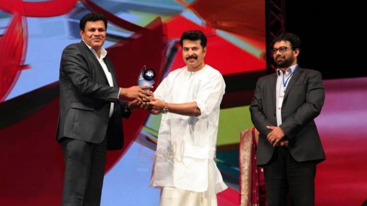 Afi Ahmed (left) receives an award from Kerala superstar Mammootty. Photo: Supplied