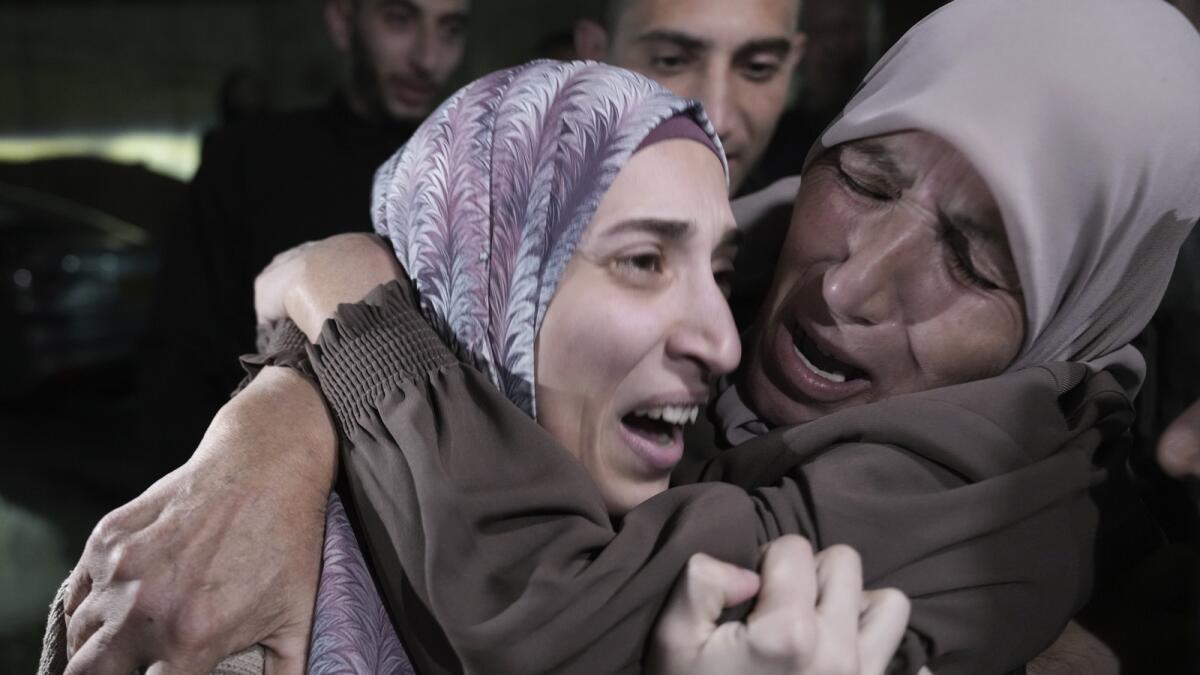 Shuruq Dwayat, left, a Palestinian prisoner released by Israel, is hugged by relatives as she arrives home in the east Jerusalem neighborhood of Sur Bahar. — AP