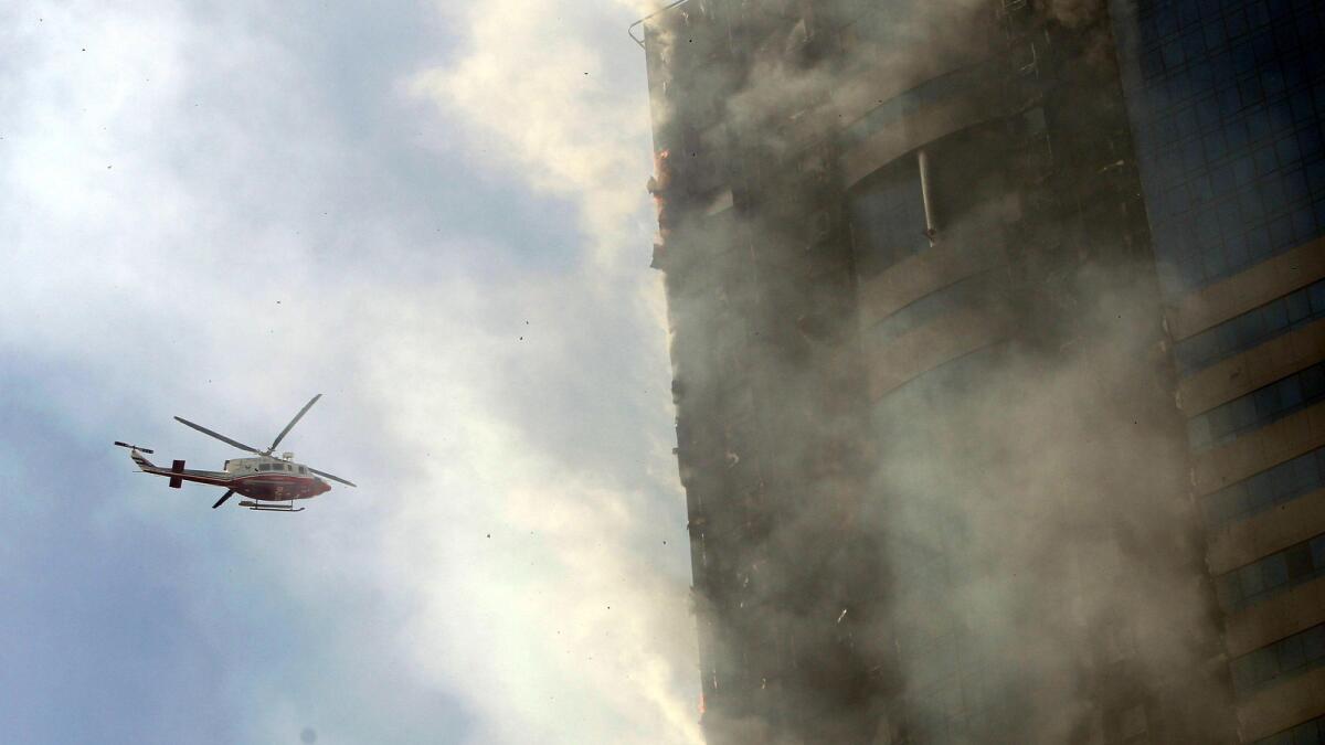A police helicopter is monitoring the fire that broke out in a residential building located on King Faisal street in Sharjah.– Photo by M.Sajjad/Khaleej Times