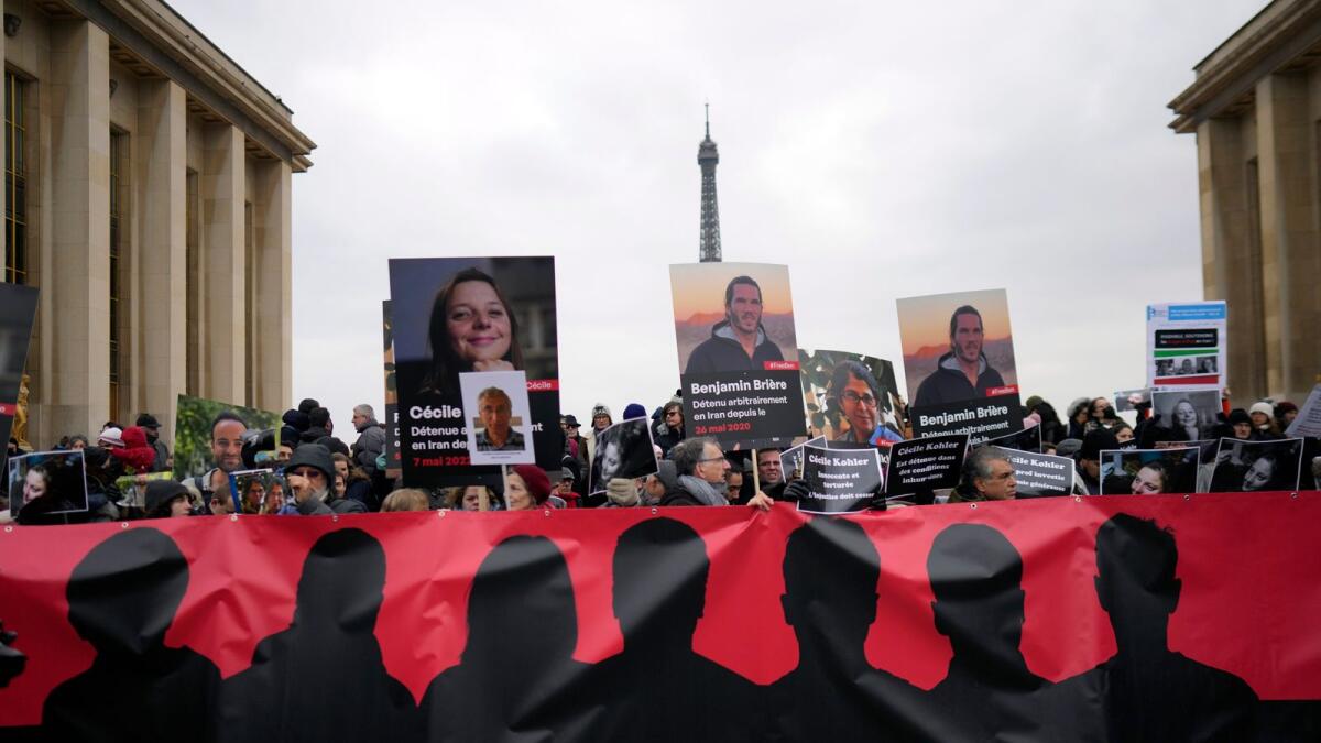 People hold portraits of French detainees in Iran Cecile Kohler and Benjamin Briere during a protest in Paris on Saturday. — AP