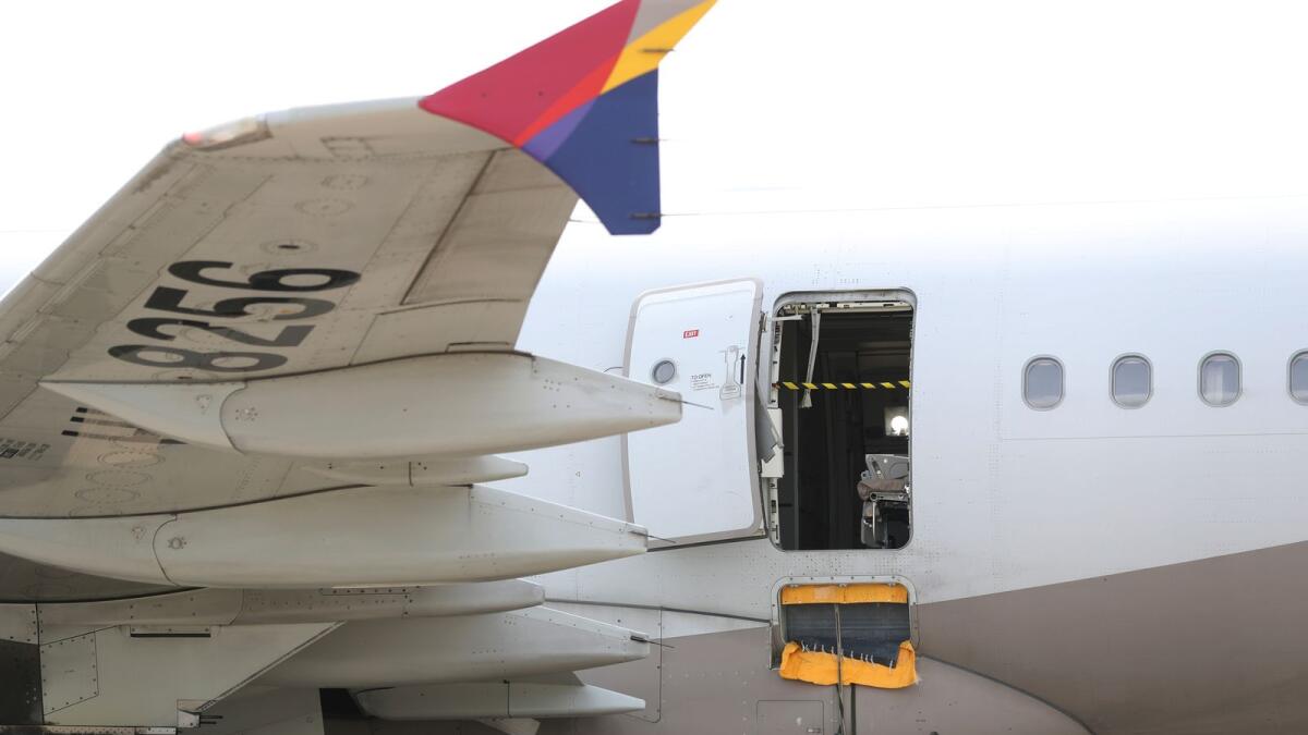 An Asiana Airlines plane is parked as one of the plane's doors suddenly opened at Daegu International Airport in Daegu, South Korea, on Friday. — AP