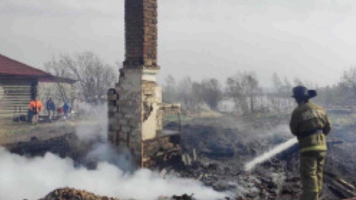 A firefighter works to extinguish a fire in the settlement of Bely Yar in the Krasnoyarsk region. — AFP