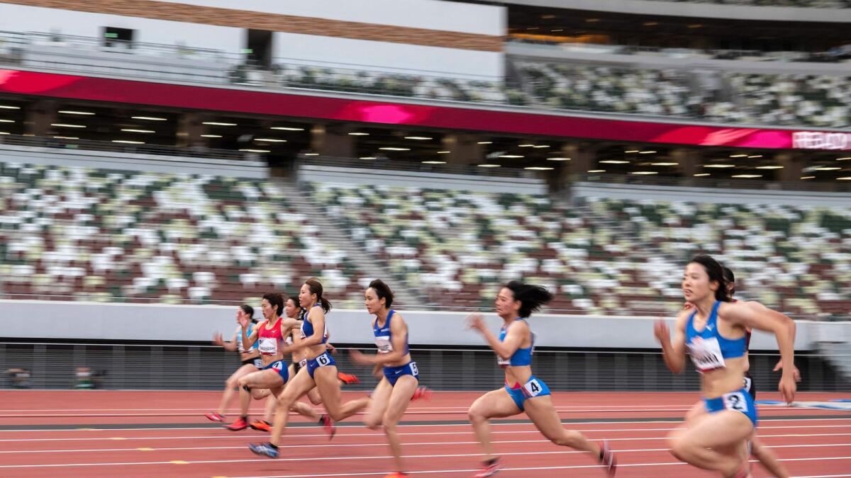 Athletes compete in a heat of the women's 100m during an athletics test event for the 2020 Tokyo Olympics at the National Stadium in Tokyo on Sunday. — AFP