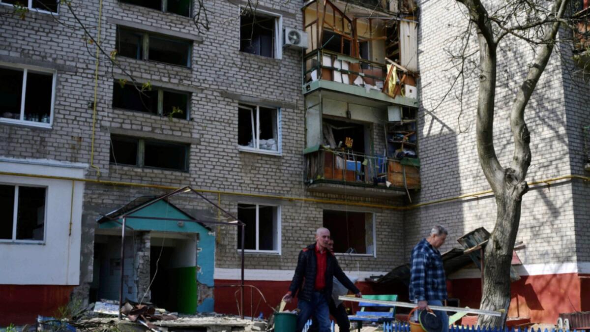 Men walk past an apartment building destroyed by night shelling in Kramatorsk. — AP