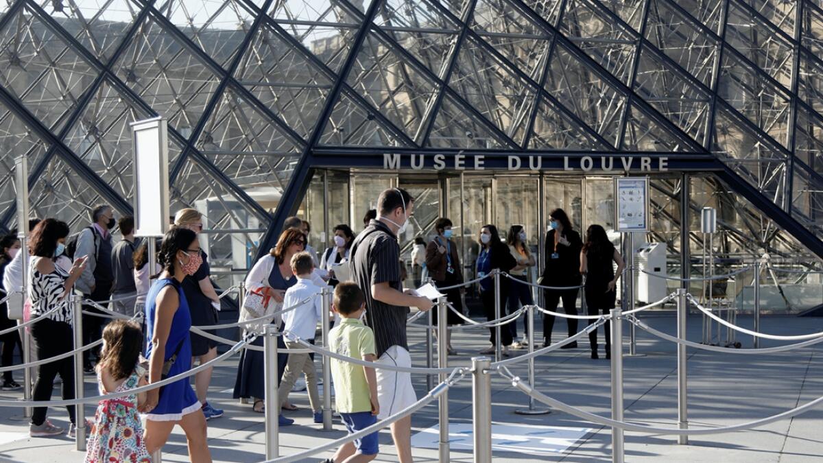 Visitors queue in front of the Louvre Pyramid designed by Chinese-born US architect Ieoh Ming Pei in Paris as the museum reopens its doors to the public after almost 4-month closure due to the coronavirus disease (Covid-19) outbreak in France. Photo: Reuters