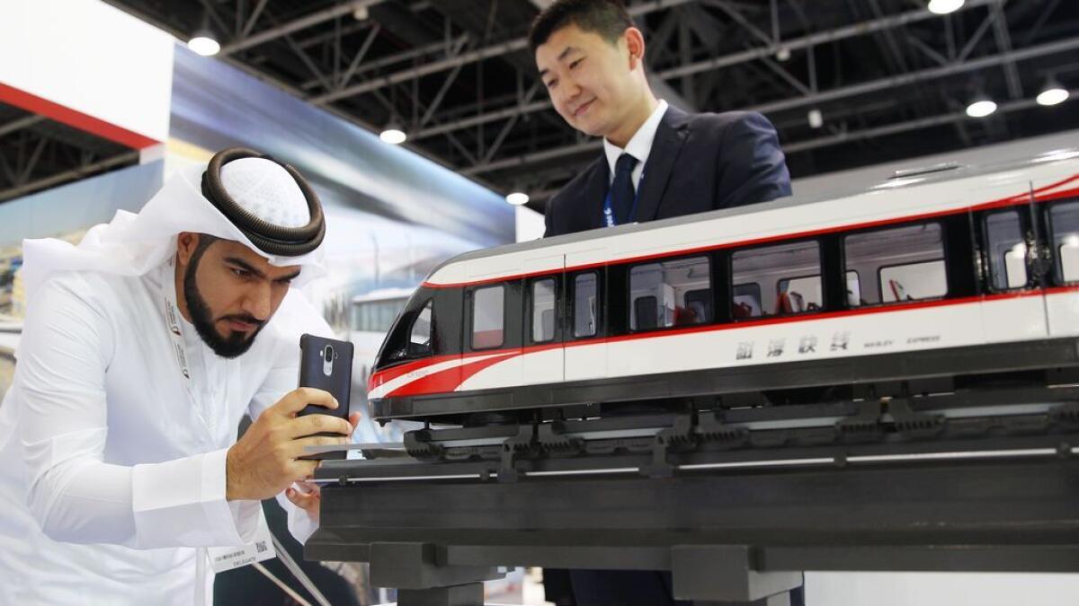 A visitor takes a picture of a 3.3 medium and low speed Maglev train at the CRRC pavilion at the Middle East Rail Exhibition.