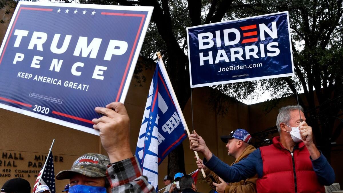 Biden-Harris and Trump-Pence supporters stand together at Vera Minter Park in Abilene, Texas as they await the arrival of the Biden-Harris campaign bus. AP