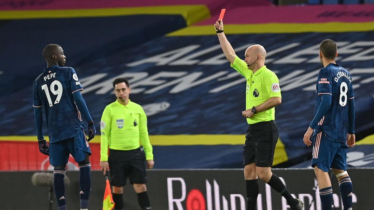 Arsenal's midfielder Nicolas Pepe (left) is shown a red card by referee Anthony Taylor during the English Premier League football match against Leeds United. — AFP