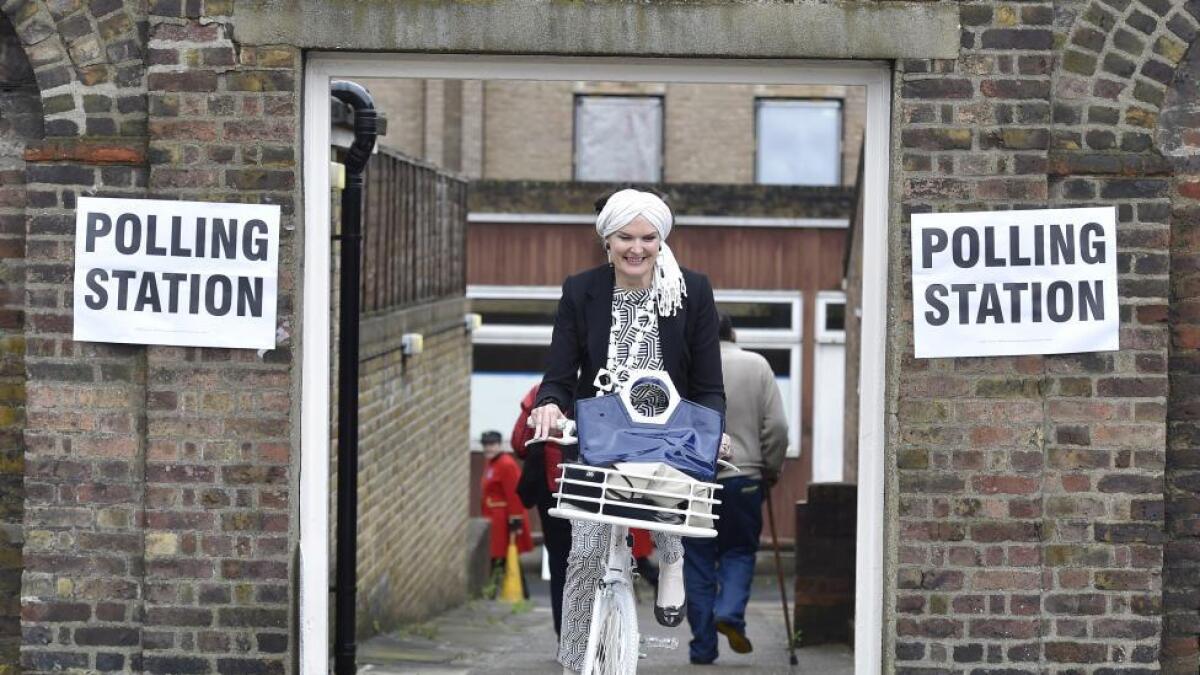 A woman cycles out of a polling station for the Referendum on the European Union in Chelsea.