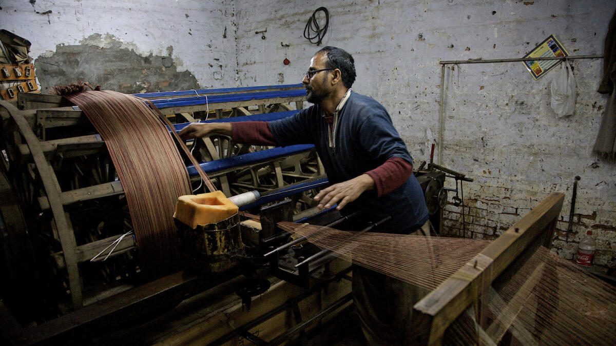 A labour prepares threads in a textile factory in Faisalabad. Pakistan is focused on its foreign trade policy reforms and removing non-tariff barriers on  some 4,000 product areas.  