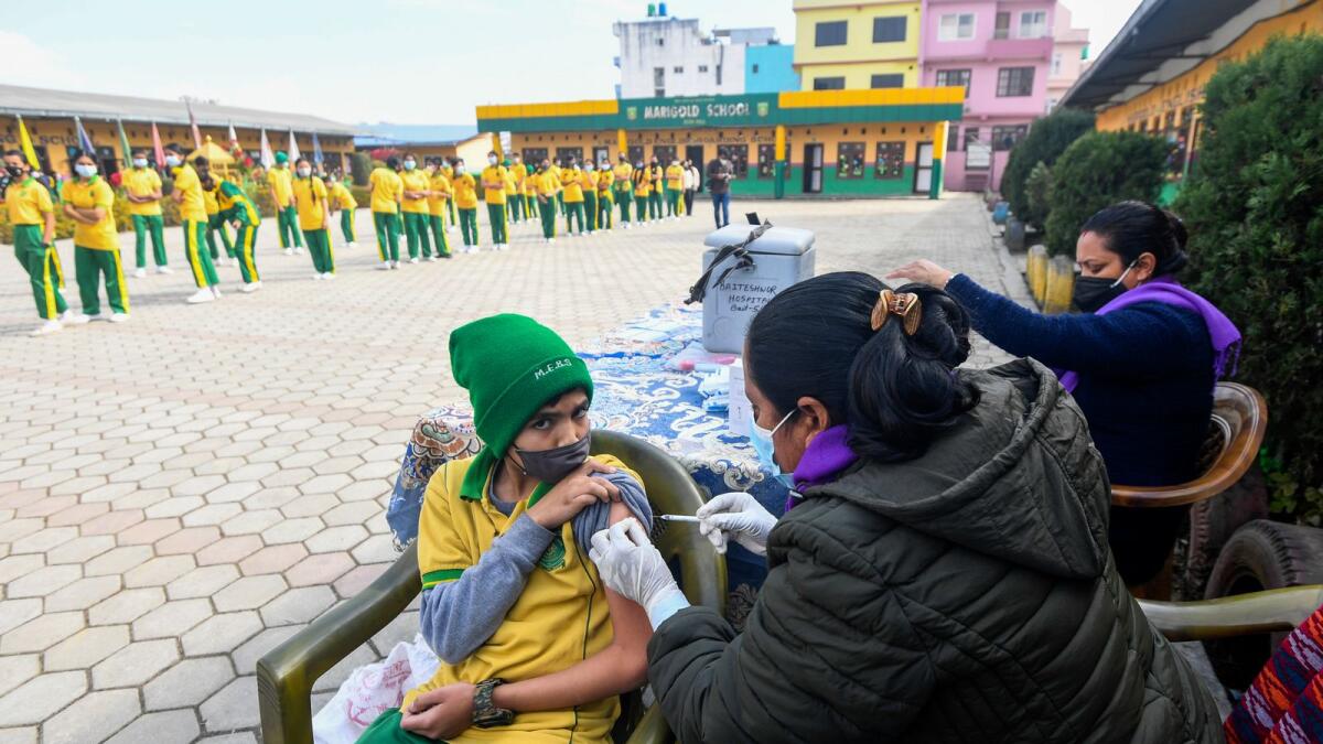 A health worker inoculates a schoolboy with the Moderna Covid-19 coronavirus vaccine at a school in Bhaktapur, on the outskirts of Kathmandu, on January 10, 2022. (Photo: AFP)