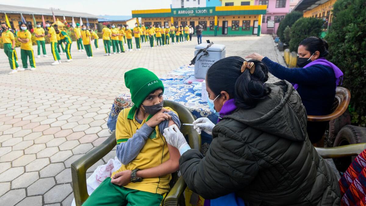 A health worker inoculates a schoolboy with the Moderna Covid-19 coronavirus vaccine at a school in Bhaktapur, on the outskirts of Kathmandu, on January 10, 2022. (Photo: AFP)
