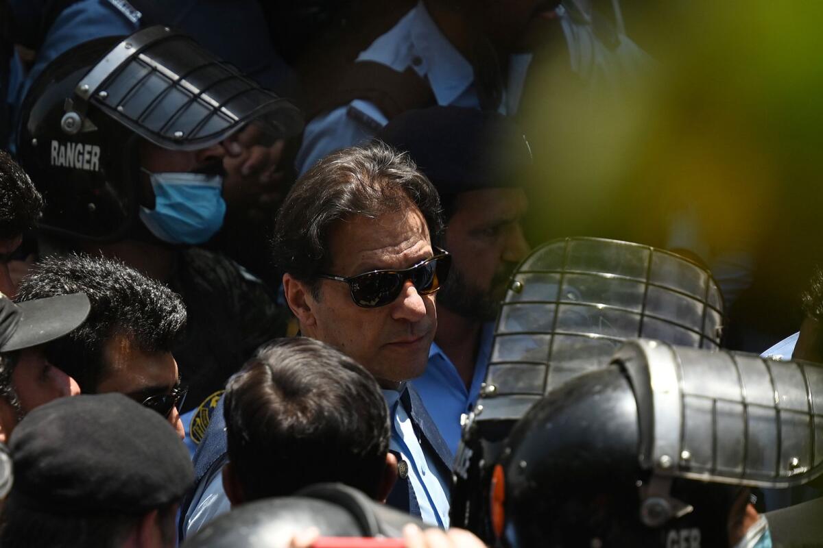 Police cammandos escort former Pakistan's Prime Minister Imran Khan (C) as he arrives at the high court in Islamabad on May 12, 2023. Photo: AFP