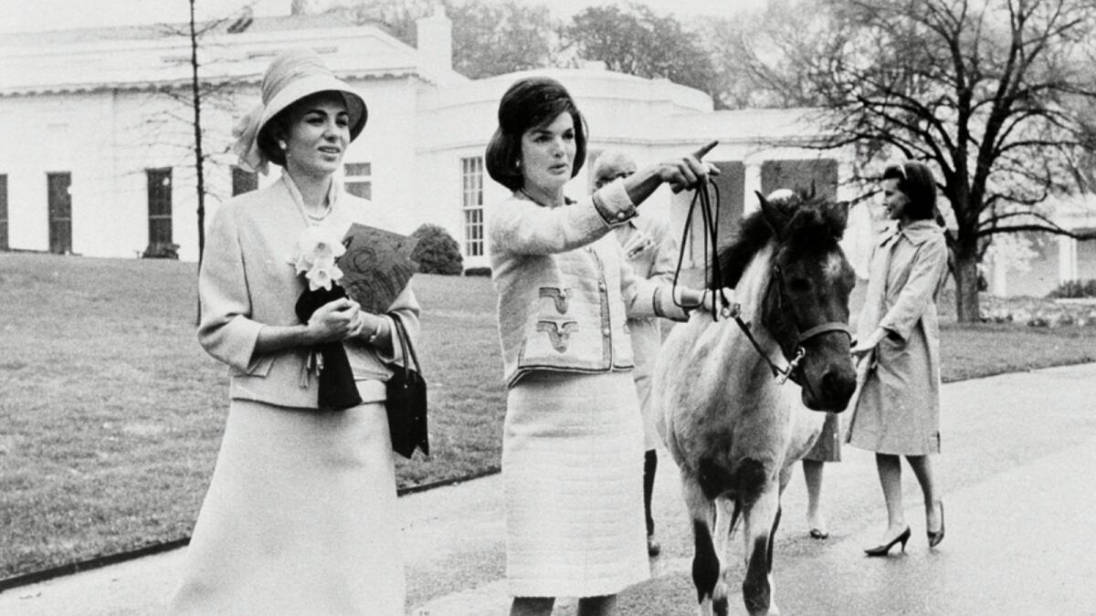 acqueline Kennedy leads her daughter Caroline's pony, Macaroni, while giving a tour of the White House grounds to Empress Farah Pahlavi of Iran, on April 12, 1962. — AP file