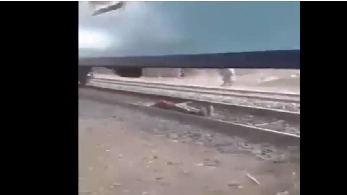 Video: Teen lies on railway track as train passes over him 