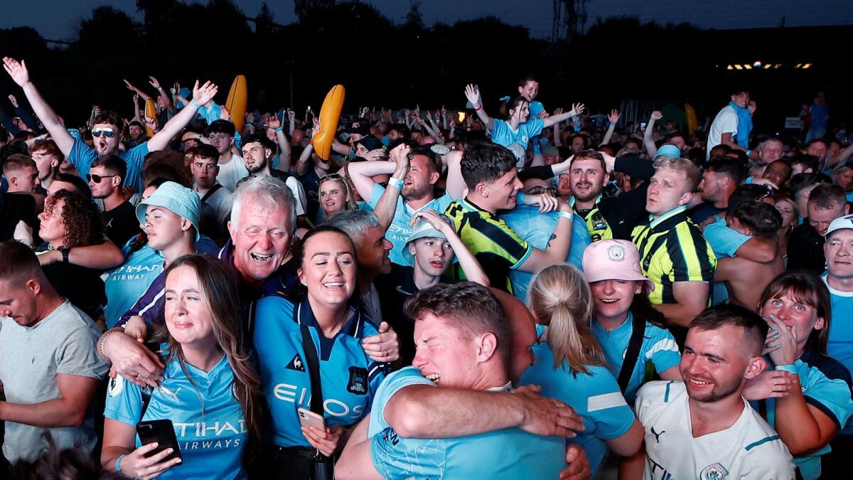 Manchester City fans celebrate after winning the Champions League final.