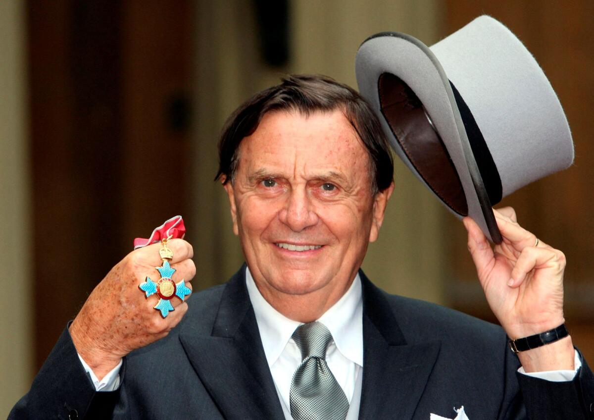 Australia's Barry Humphries poses after receiving his Most Excellent Order of the British Empire from the Queen at Buckingham Palace, London, on October 10, 2007. — Reuters file