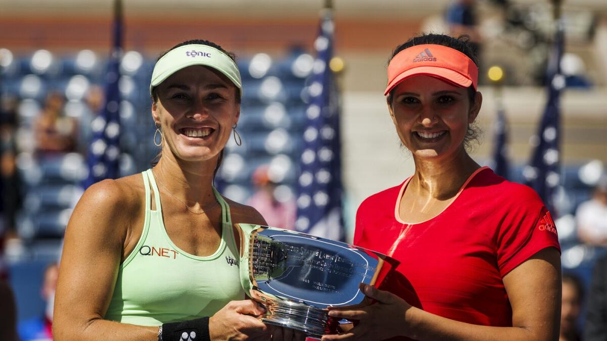 Sania Mirza of India (R) and Martina Hingis of Switzerland celebrate after winning the 2015 US Open women's doubles title at the U.S. Open Championships Tennis tournament in New York, September 13, 2015.  Reuters photo