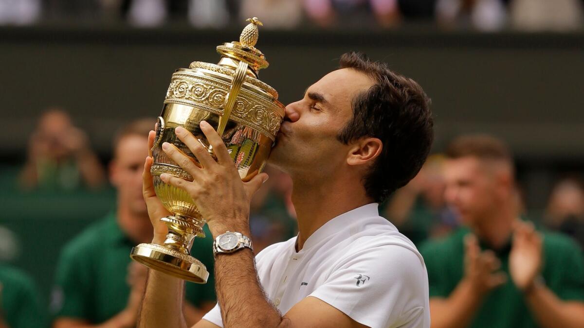 Roger Federer kisses the trophy after winning the 2017 Wimbledon title. (AP)