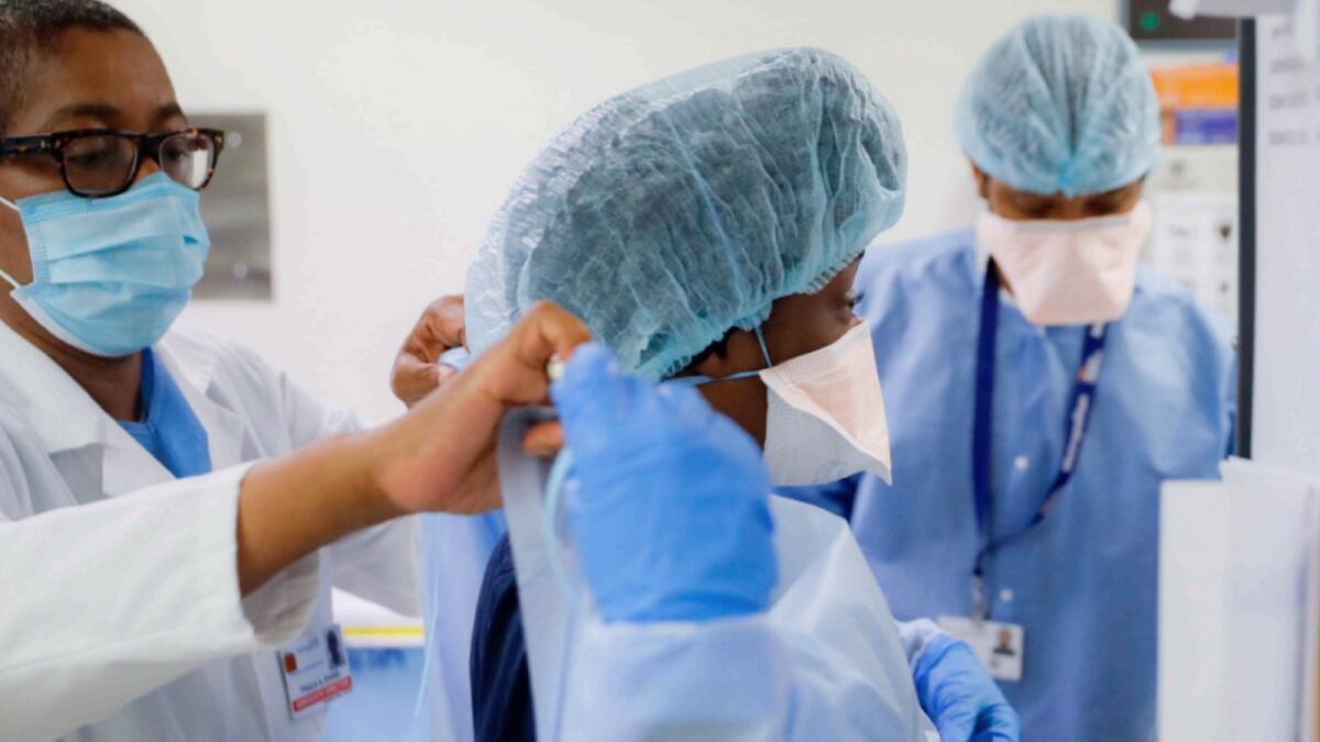 Medical personnel adjust their personal protective equipment while working in the emergency department at NYC Health + Hospitals Metropolitan in New York. — AP file