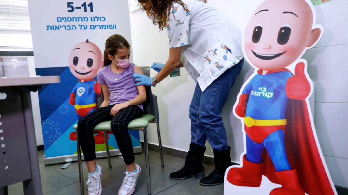 Israeli girl Danae Vitkin, 9, receives her first Pfizer-BioNTech Covid-19 vaccine from medical staff at Clalit Health services in Tel Aviv. — AP
