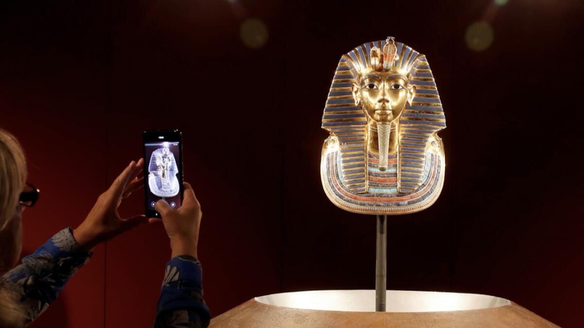 A woman takes a picture of a true-to-scale replica mask of ancient Egypt king Tutankhamun during a media preview of the exhibition 'Tutankhamun: His Tomb and Treasures', as the coronavirus disease (Covid-19) outbreak continues, in Zurich, Switzerland. Photo: Reuters