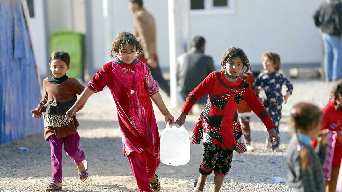 Iraqi children carrying jerrycans of water. The region is already facing a severe water crisis, and with temperatures expected to rise in coming years, the problem could get worse. — AFP file