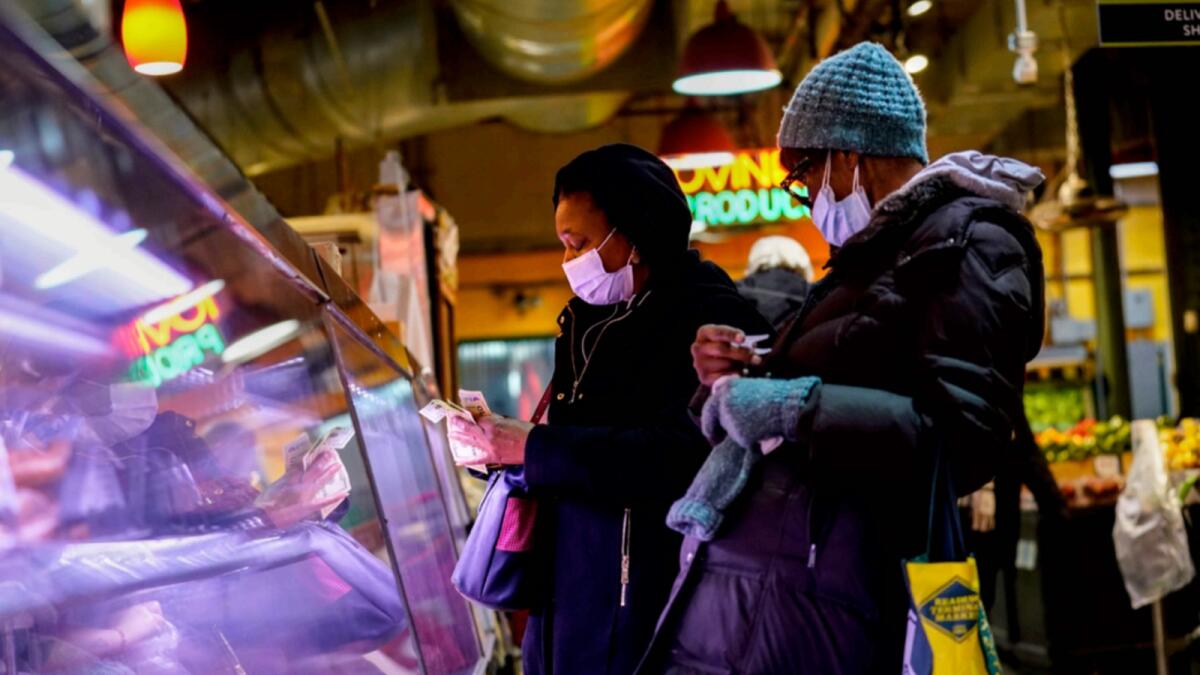 Customers wearing face masks to protect against the spread of the coronavirus shop at the Reading Terminal Market in Philadelphia. — AP