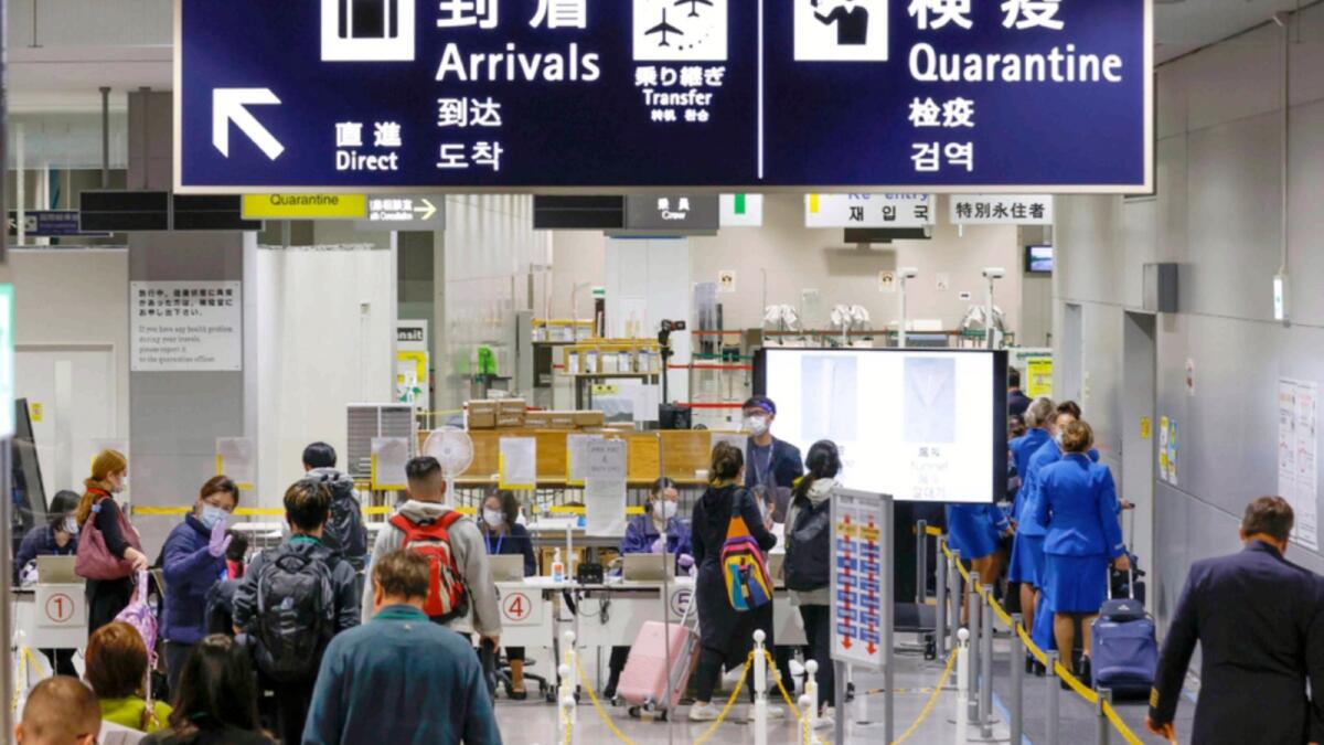 Passengers wait in a line to receive PCR test kit at quarantine counter of the airport on their arrivals at Kansai International Airport in Osaka. — AP