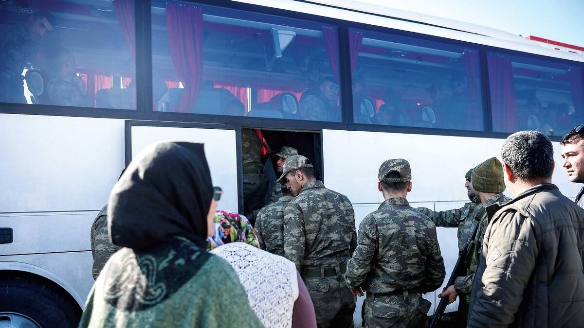 Family members bid farewell to soldiers boarding a bus as they are dispatched to the border with Syria, at Hassa, Turkey. — AFP