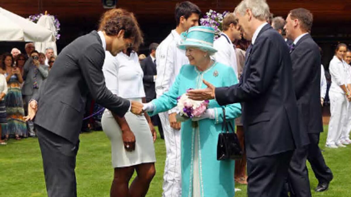 Swiss ace Roger Federer (left) bows as he meets Britain's Queen Elizabeth II during her visit to Wimbledon in 2010. — AFP