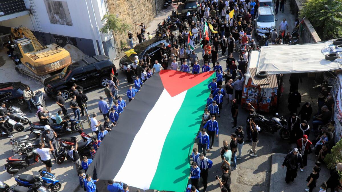 Local scouts carry a large Palestinian flag during a march to express solidarity with Palestinian people in Beirut. — AFP