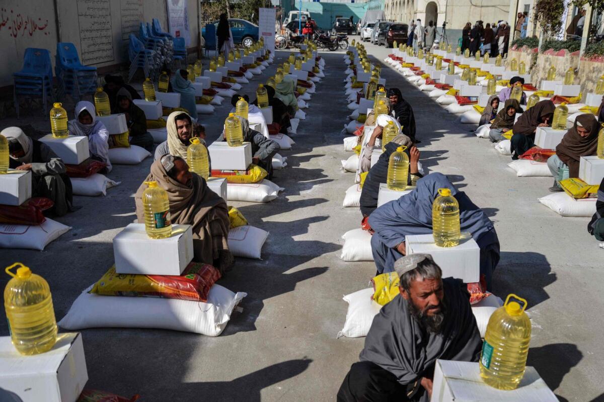 Afghan refugees deported from Pakistan received food aid by the Red Cross Society in Kandahar on January 24, 2024.— AFP