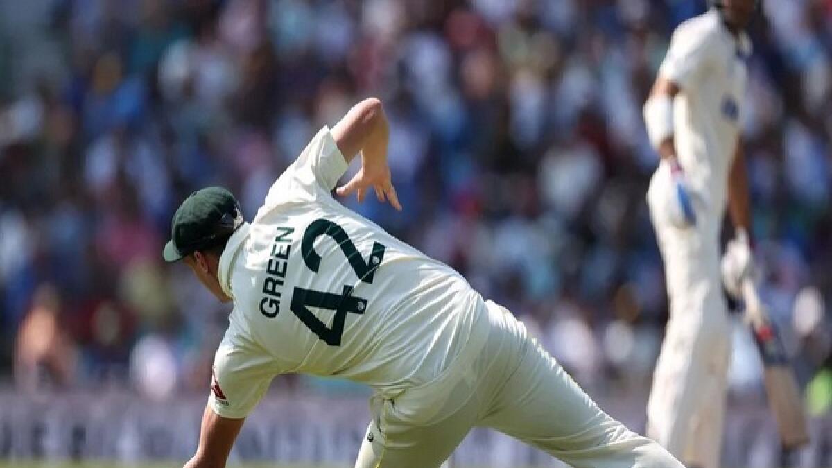 Cameron Green lunges to his left to make the controversial catch during the fourth day;s play of the World Test Championship between India and Australia at the Oval on Saturday. - AFP