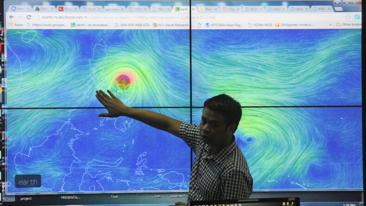 Meteorologists from the Philippine Atmospheric Geophysical and Astronomical Services Administration (PAGASA) monitor and plot the direction of powerful Typhoon Melor at their headquarters in suburban Manila on December 14, 2015. (AFP photo)