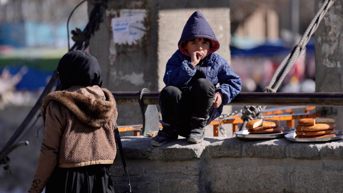 A boy selling bread watches Friday Prayer in Kabul. — AP