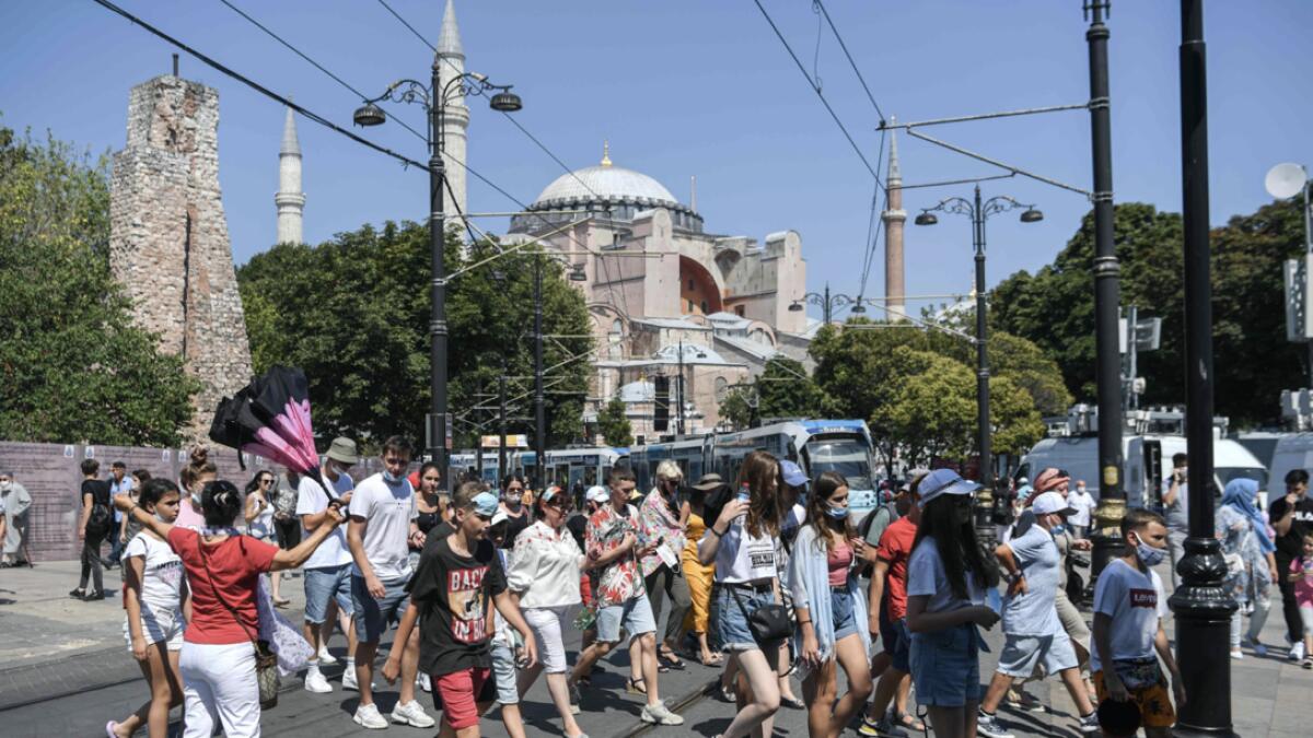 A group of tourists walk past Hagia Sophia as they go toward the historical Sultanahmet district in Istanbul, Turkey. Photo: AFP