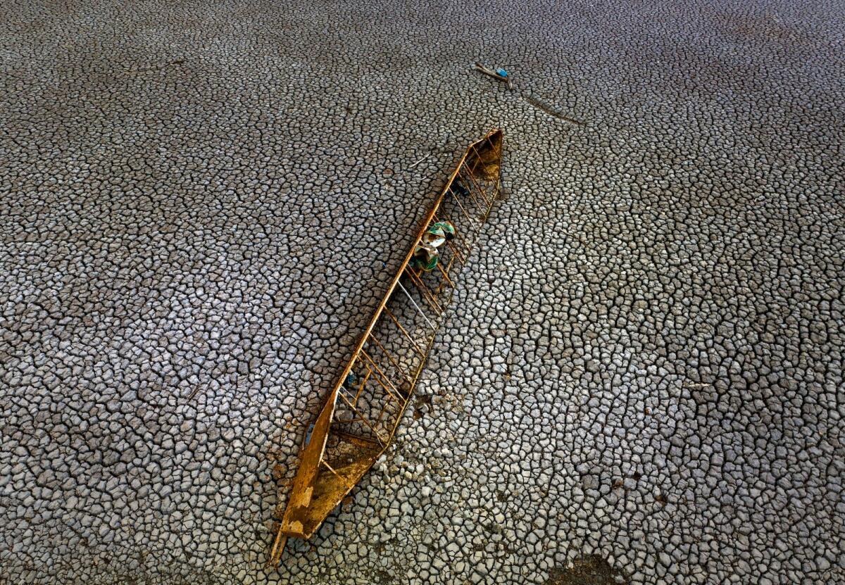 An old boat is photographed half-buried after the water level has dropped at the Sau reservoir, about 100km north of Barcelona, Spain, on April 18, 2023. — AP