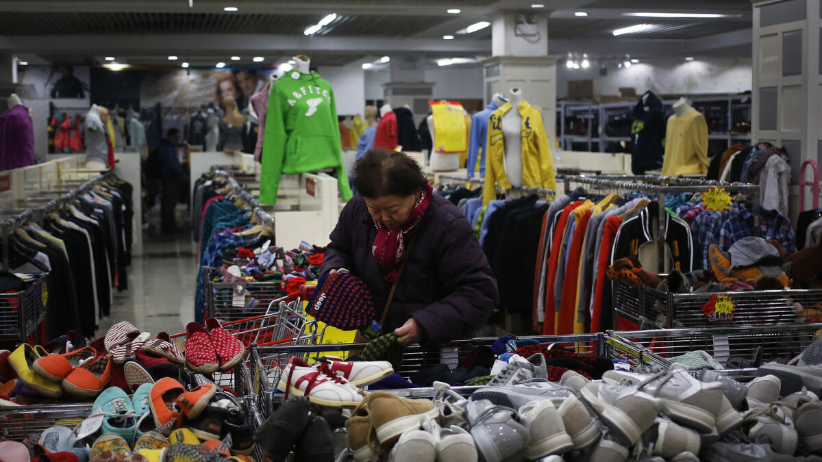 A woman selects winter hat at a Chinatown foreign trade mall in Beijing, Tuesday, March 1, 2016. China's manufacturing lost momentum again last month, according to two surveys of factory activity released Tuesday that highlighted sluggish conditions in the world's second biggest economy. — AP