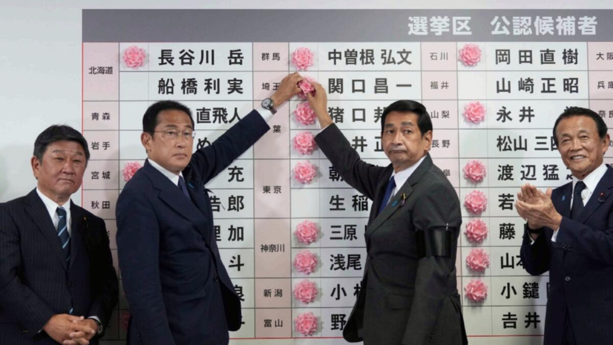 Fumio Kishida, second left, Japan's prime minister and president of the Liberal Democratic Party (LDP), speaks after placing a red paper rose on an LDP candidate's name, to indicate a victory in the upper house election. — AP