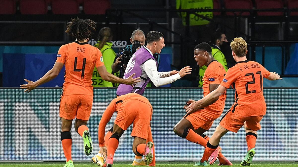Netherlands' defender Denzel Dumfries (second from right) celebrates with teammates after scoring the third goal. (AFP)