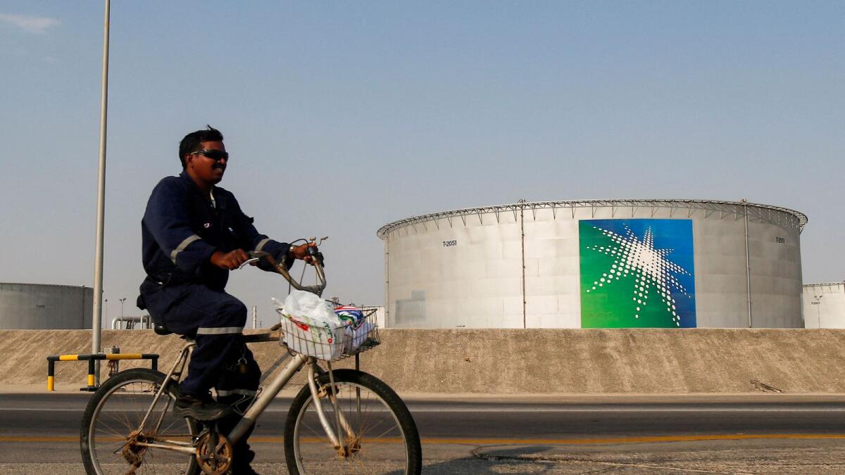 An employee rides a bicycle next to oil tanks at Saudi Aramco oil facility in Abqaiq, Saudi Arabia. — Reuters file
