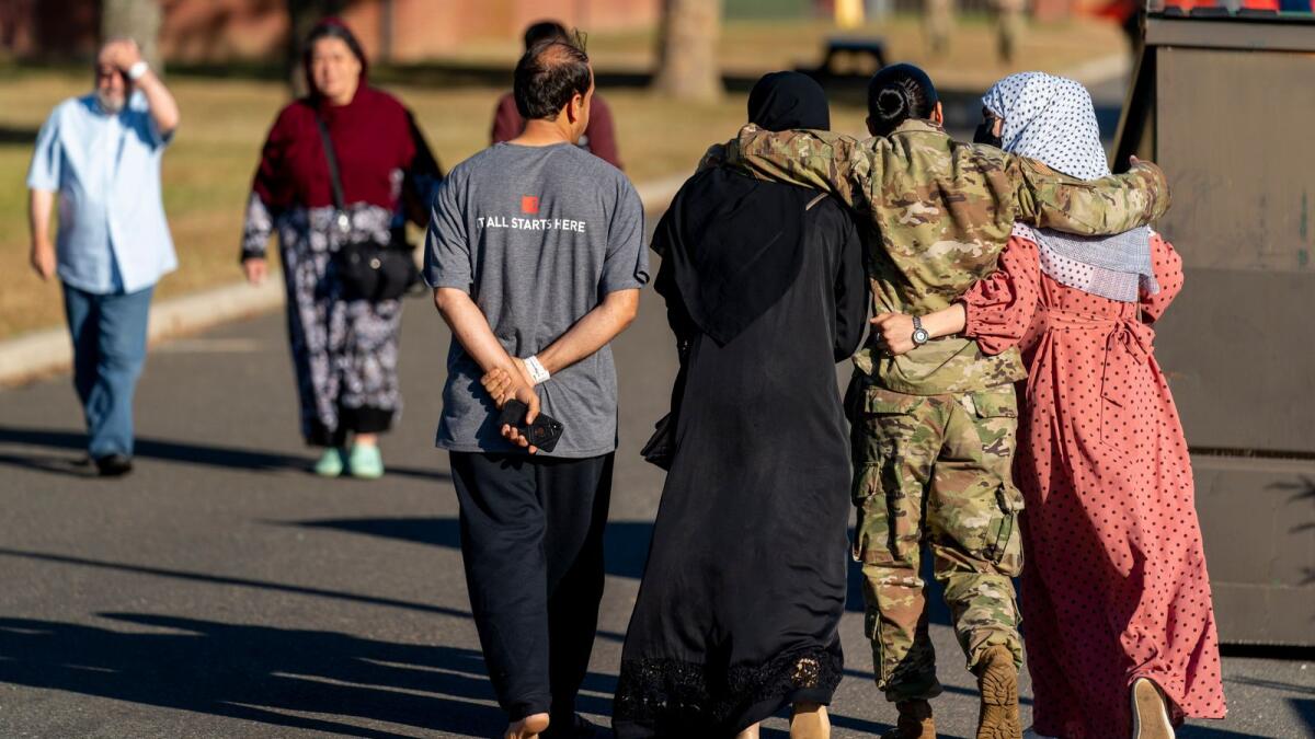 A female member of the military puts her arms around two female Afghan refugees after they spoke with Secretary of Defence Lloyd Austin during his visit to an Afghan refugee camp on Joint Base McGuire Dix Lakehurst, New Jersey. — AP file
