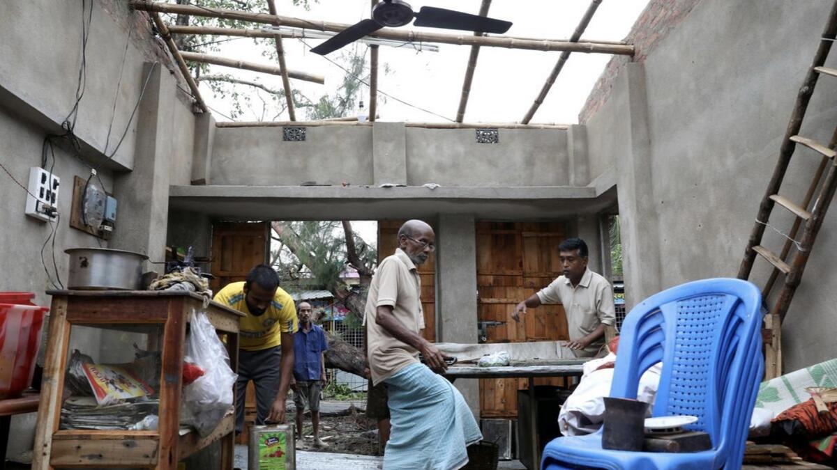 Men salvage items from a damaged shop after Cyclone Amphan made its landfall, in South Parganas district in the eastern state of West Bengal, India.  Reuters