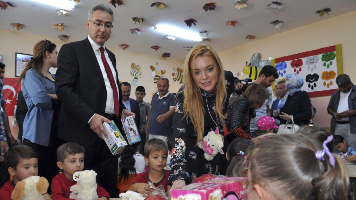 U.S. actress Lindsay Lohan gives presents to Syrian refugee children as she visits a Turkish government-run Syrian refugee camp in Nizip.