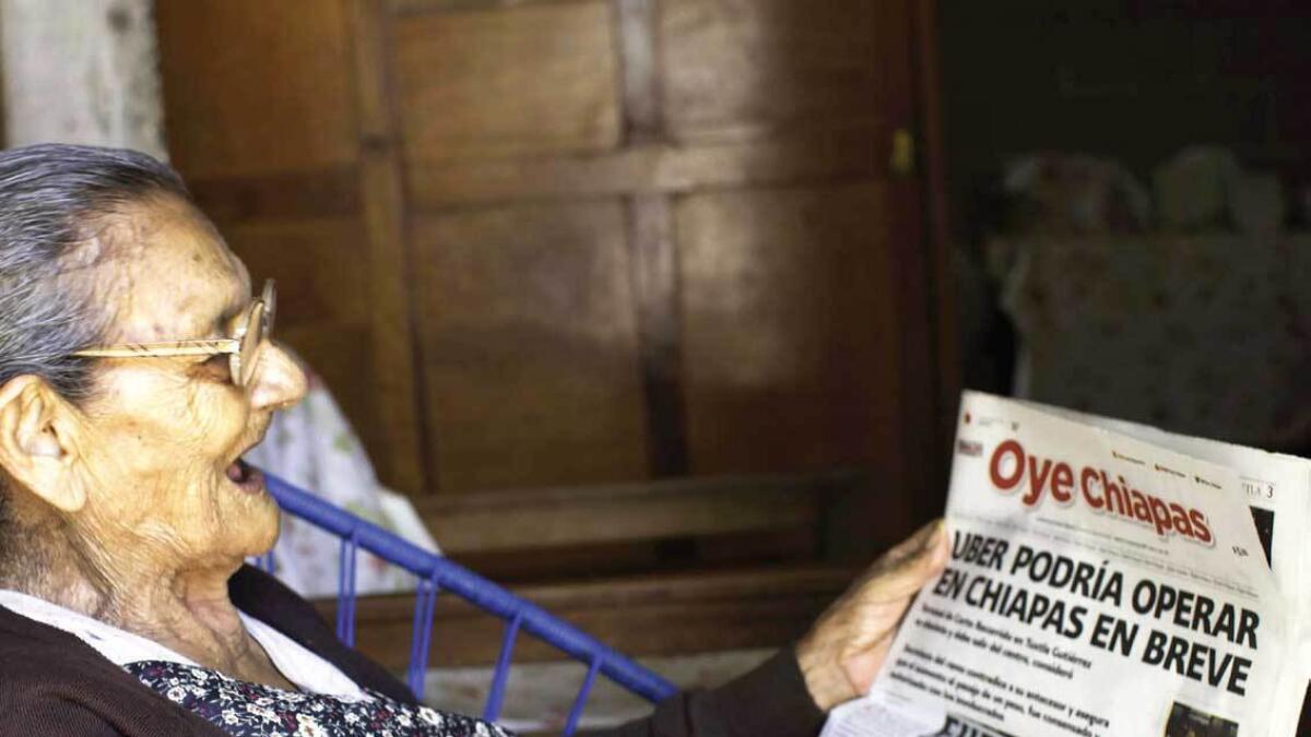 Mexican Guadalupe Palacios Garcia reads the newspaper at her house in Tuxtla Gutierrez, Mexico, on Thursday. — AFP