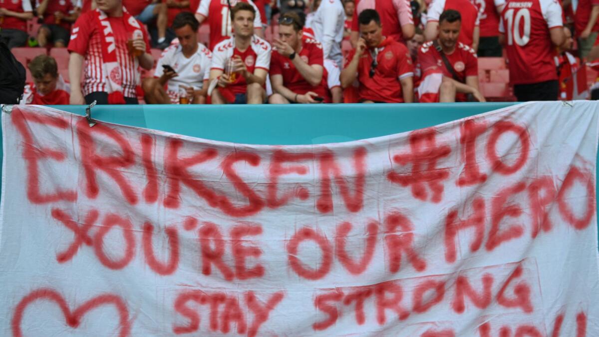 Denmark fans are seen behind a banner in support of midfielder Christian Eriksen after the Euro match between Denmark and Belgium in Copenhagen on June 17, 2021. Eriksen suffered a cardiac arrest during his country's first match of the tournament. (AFP)