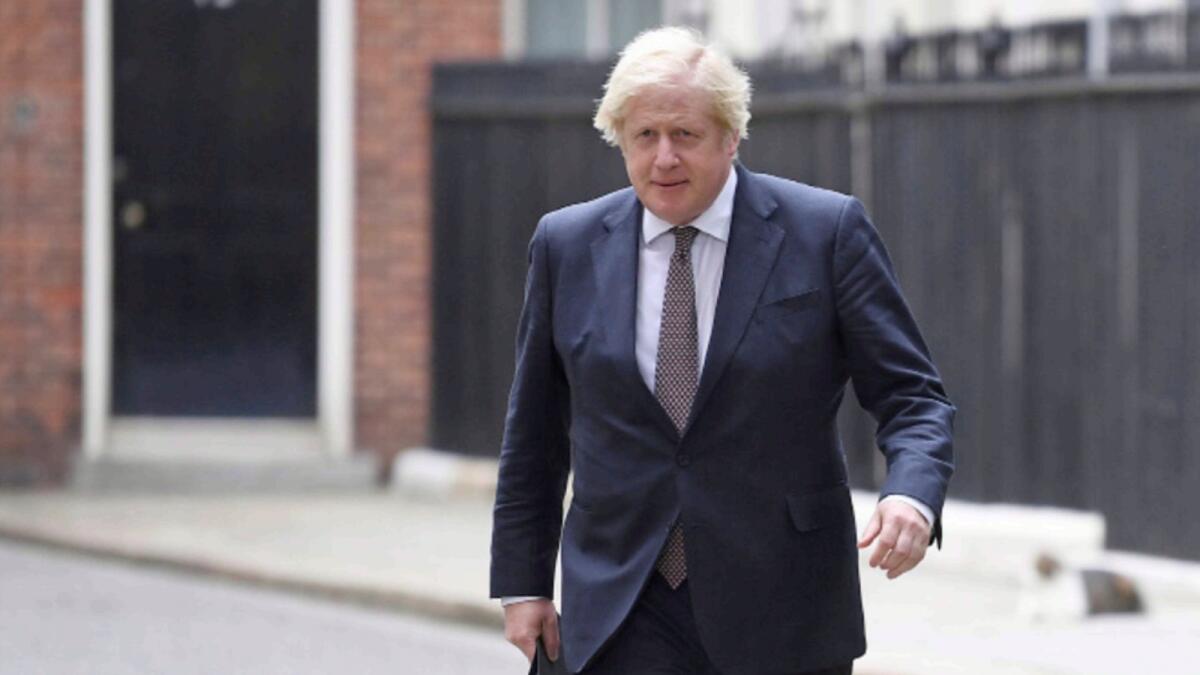 British Prime Minister Boris Johnson walks to hold a news conference for England's Covid-19 lockdown easing announcement in London. — Reuters