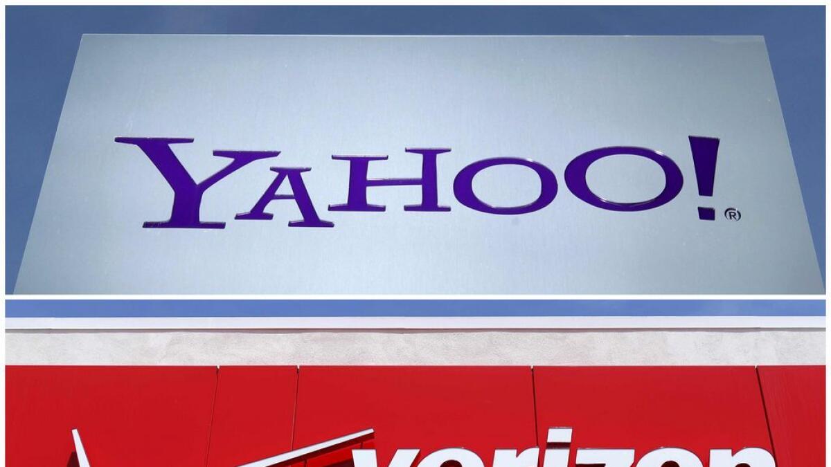A combination photo shows Yahoo logo in Rolle, Switzerland (top) in 2012 and a Verizon sign at a retail store in San Diego, California, US.